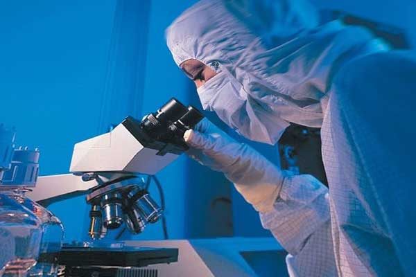 ученый в лаборатории и микроскоп