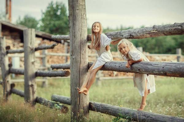 дети сидят на заборе