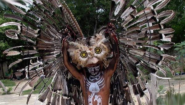 индеец в украшении из совиных перьев