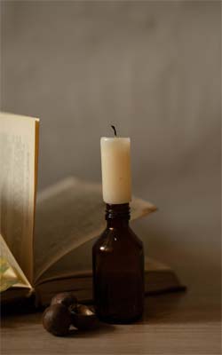 белая свеча в пузырьке и книга