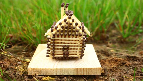 игрушечный домик из спичек на траве