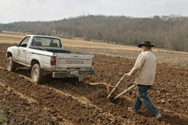 пашня, мужчина, плуг и тойота