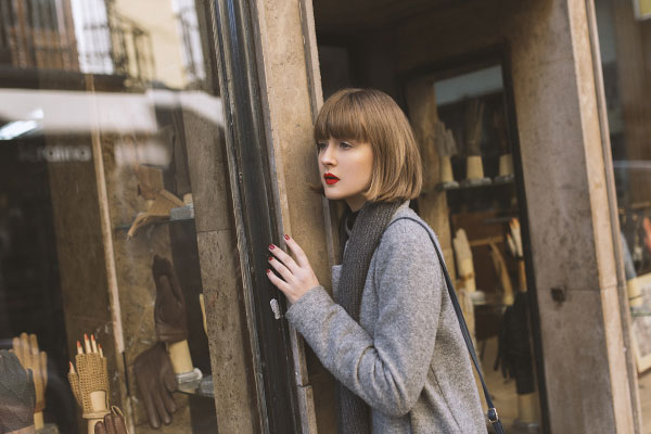молодая девушка возле витрины магазина