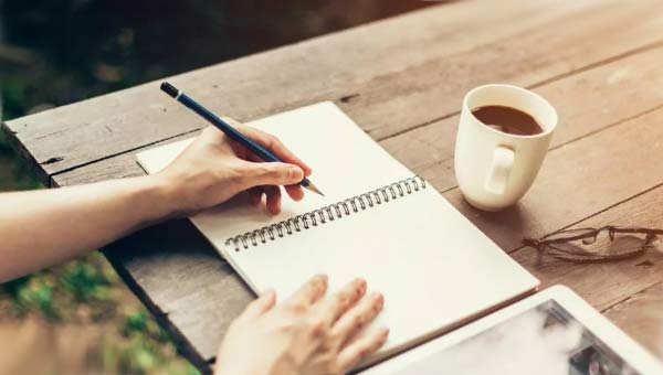 человек пишет в блокнот