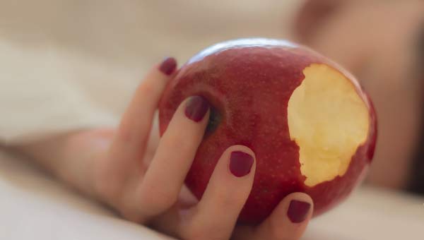 надкусанное яблоко в руке